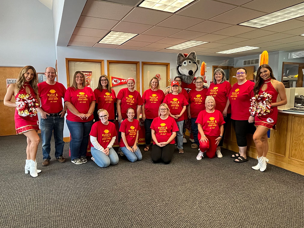 Credit Union employees with KC Chiefs cheerleaders and mascot.