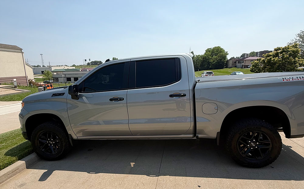 Side image of pickup truck. The Truck is medium gray wiht black wheels.